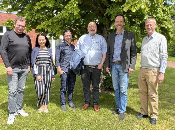 Gruppenbild mit sechs Personen, Außenaufnahme vor einem Gebäude